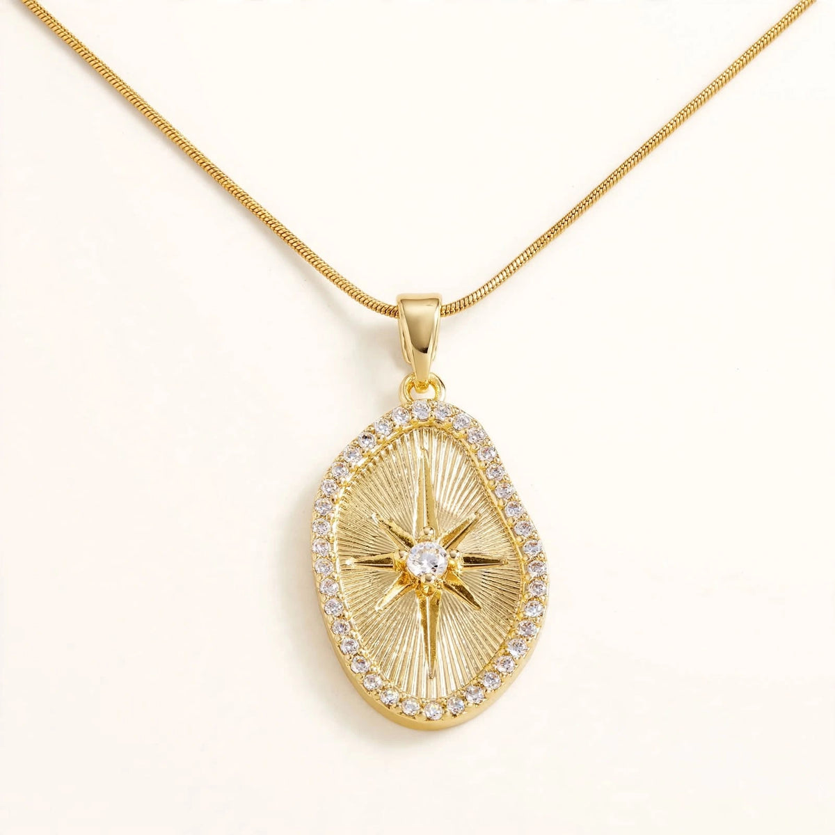 Gold sunburst oval pendant on snake chain