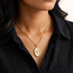 Indian woman in black shirt wearing small sunburst pendant
