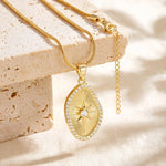 Gold sunburst pendant necklace elevated on beige stone blocks on cream linen