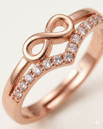 Extreme macro close-up of rose gold infinity ring with CZ stones, showing center design details on off-white background.