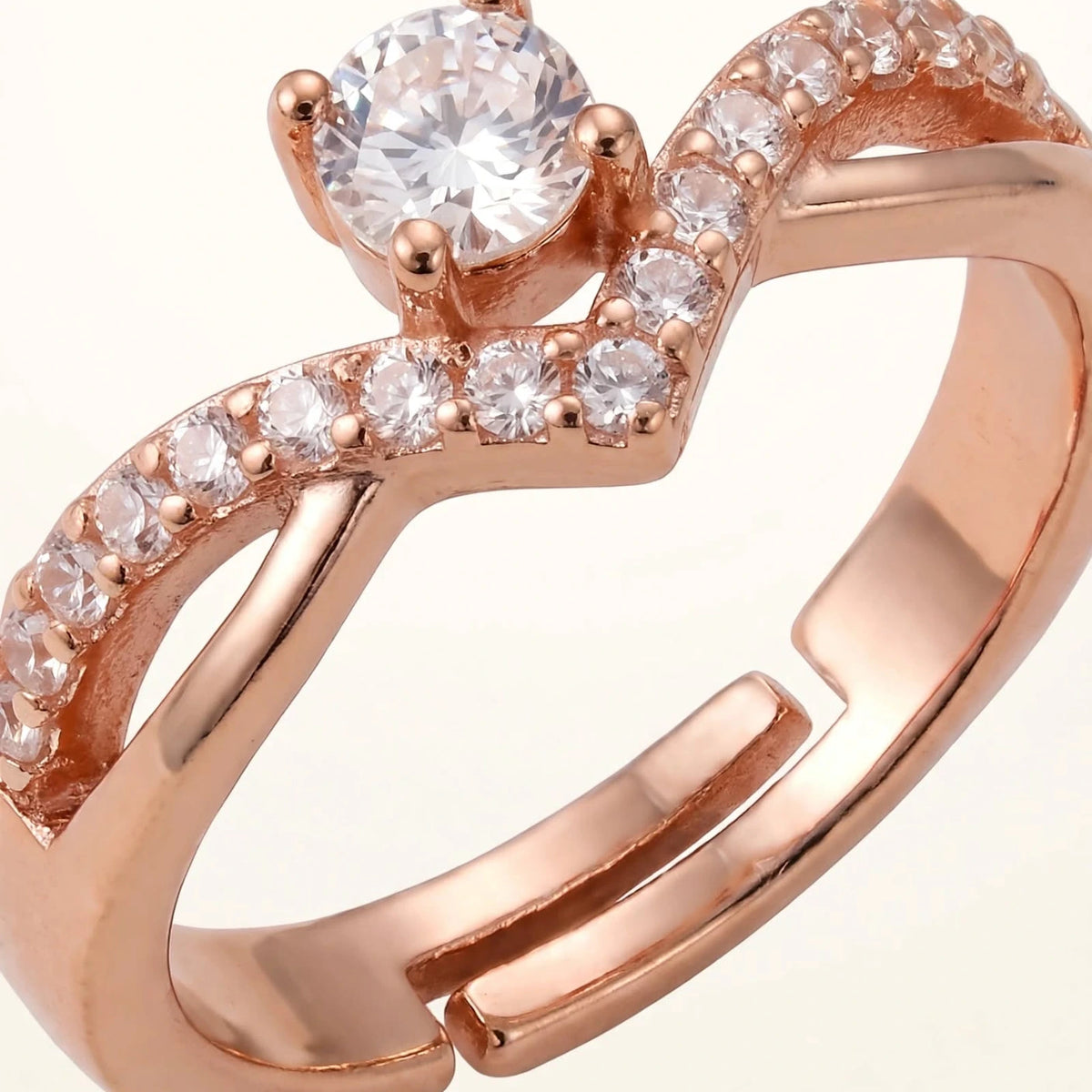 Extreme macro of rose gold V ring with central solitaire and pave stones showing open band