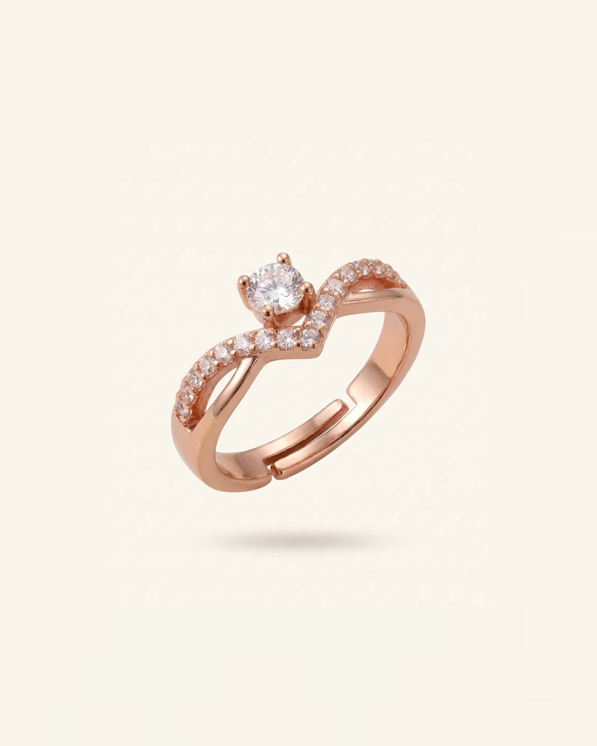 Rose gold solitaire crown ring floating elegantly on a clean warm off-white background.