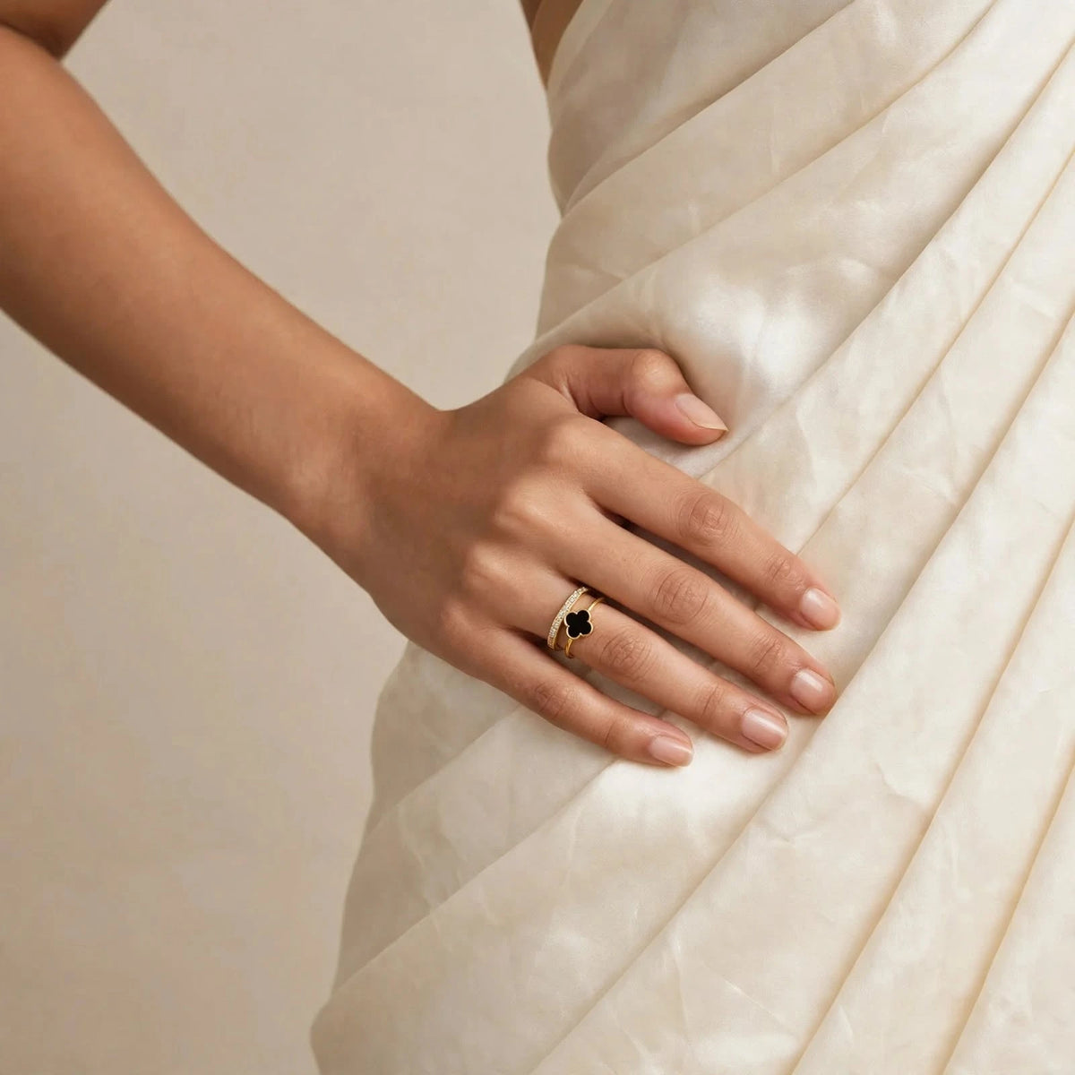 Indian woman in ivory saree hand on hip wearing black clover crystal gold ring
