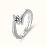 Silver adjustable open bypass ring with round diamond solitaire floating on off-white.