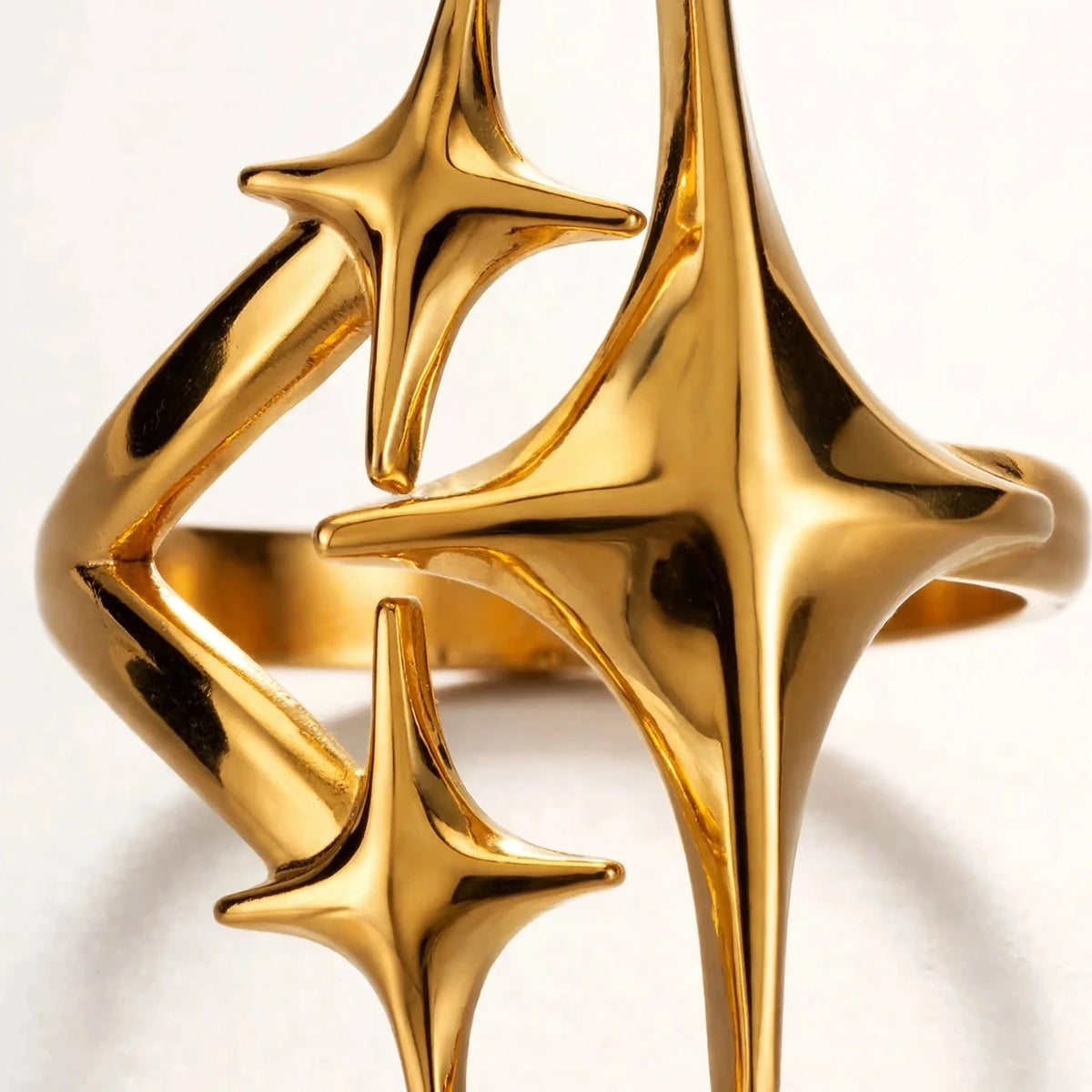 Extreme macro of gold triple star ring top showing open ends and polished detail