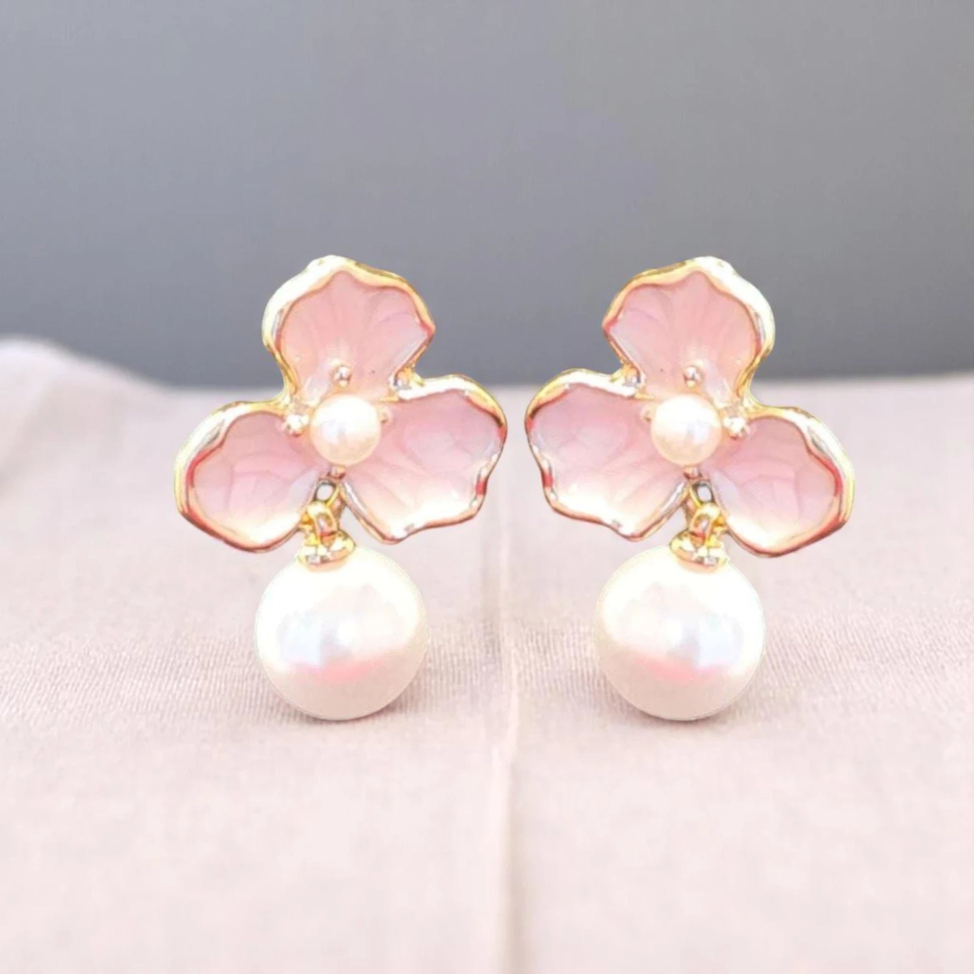 Delicate pink flower earrings adorned with pearls, featuring gold accents and a vintage-inspired design.