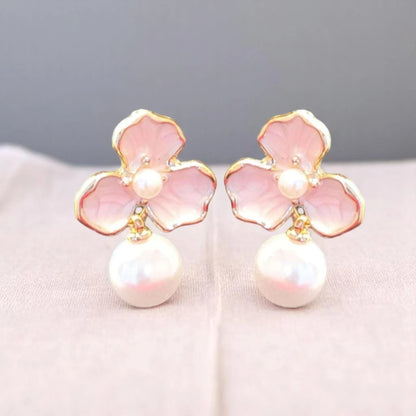 Delicate pink flower earrings adorned with pearls, featuring gold accents and a vintage-inspired design.