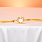 Bracelet on white nylon cloth with a peach-colored gradient in the background.