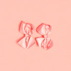 Two pink bows on a light background