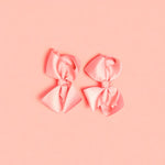 Two pink bows on a light background