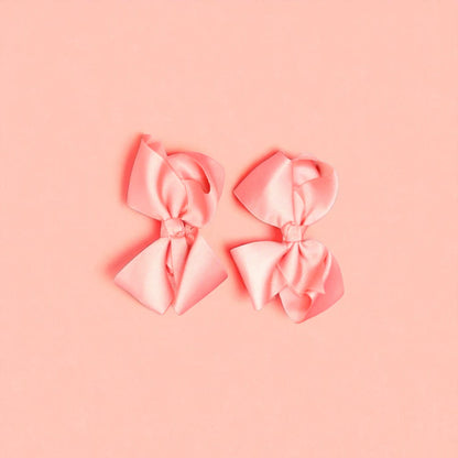 Two pink bows on a light background