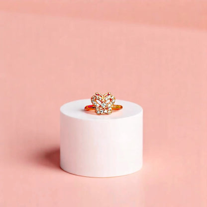 Ring on a white cylindrical geometric prop with a peach color gradient in the background.