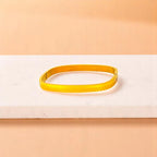 Bracelet on geometric prop with peach color gradient in the background.