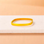 Bracelet on geometric prop with peach color gradient in the background.