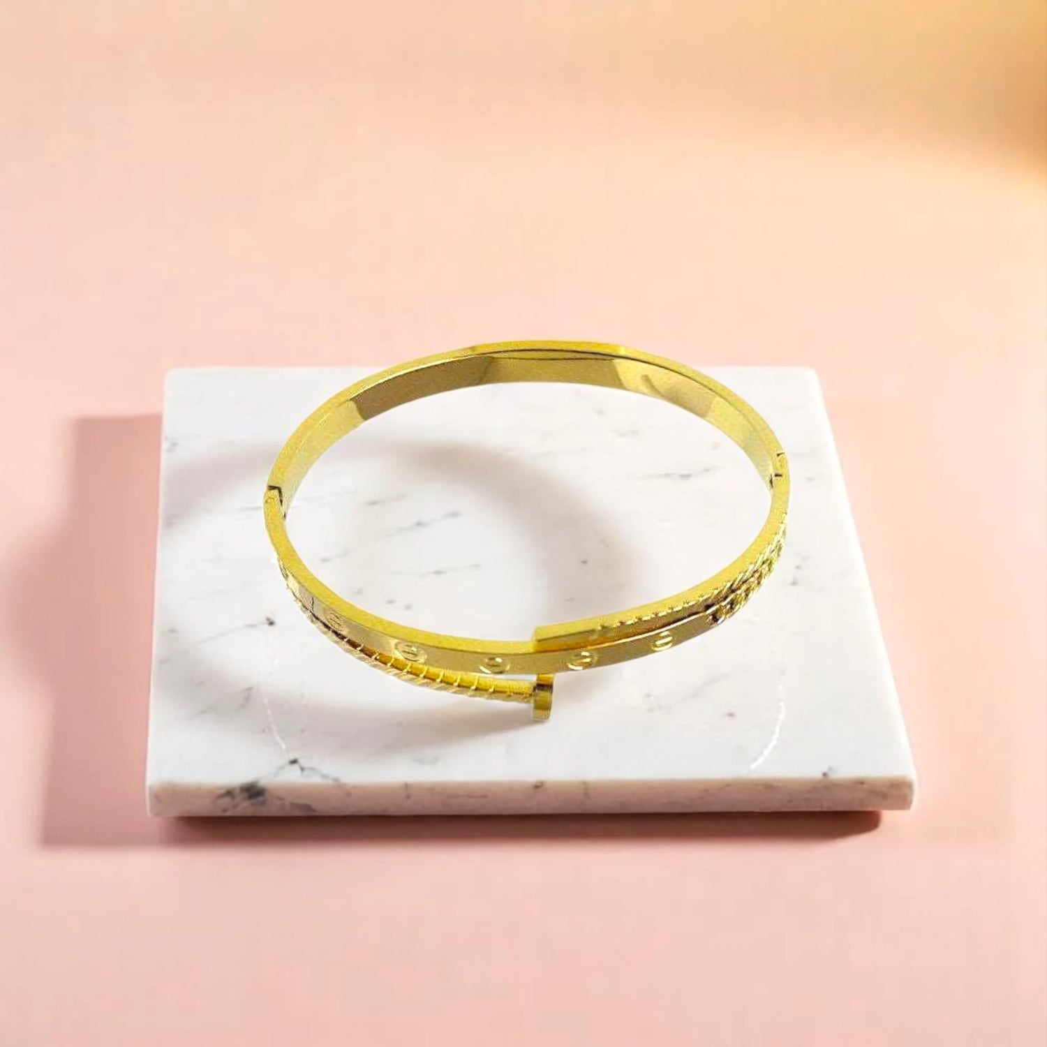 Bracelet on geometric prop with peach color gradient in the background.