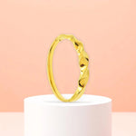 Bracelet displayed on a white pedestal against a soft peach background.