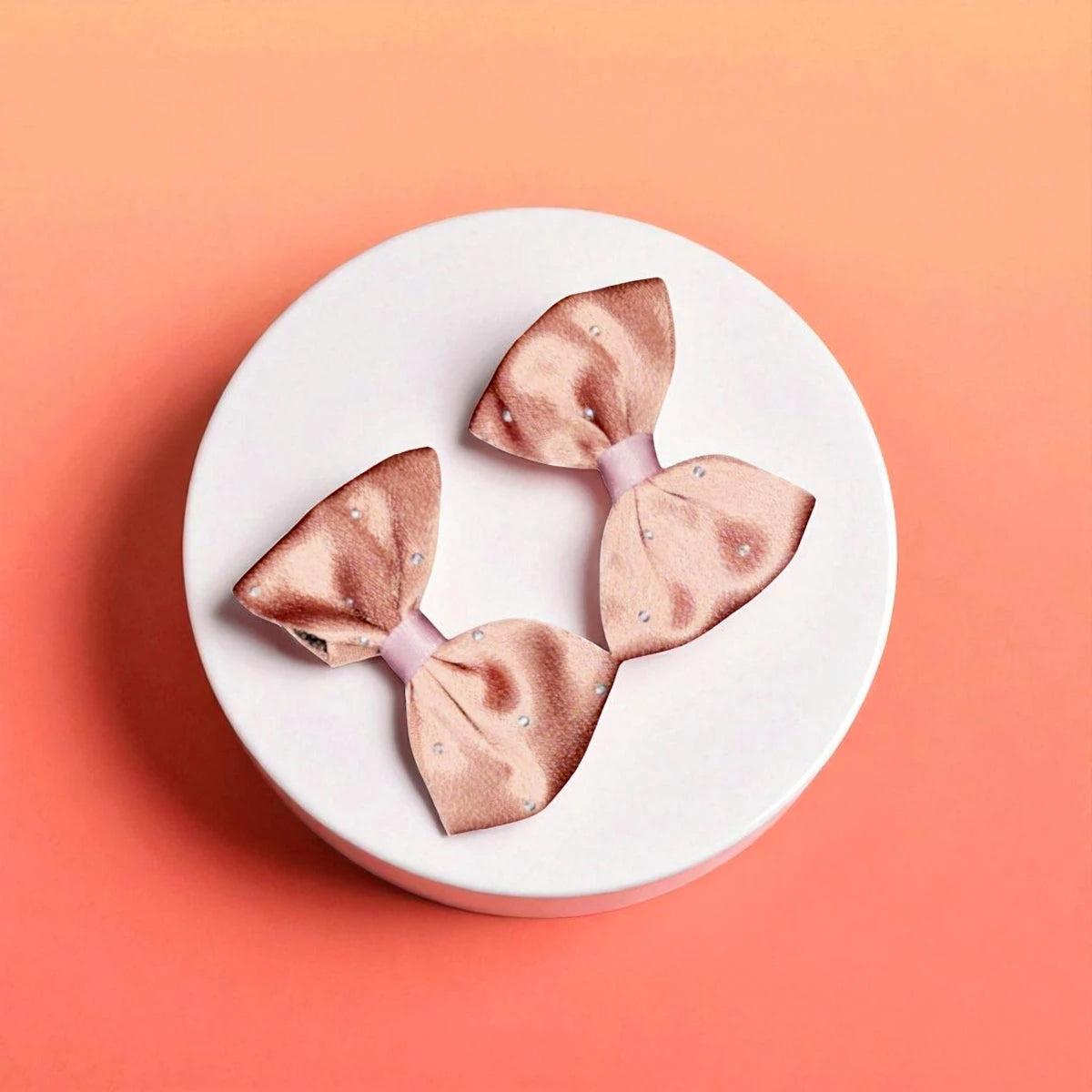 Two brown bows on a white acrylic pedestal with light background