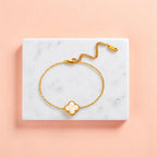 Bracelet on geometric prop with peach color gradient in the background.