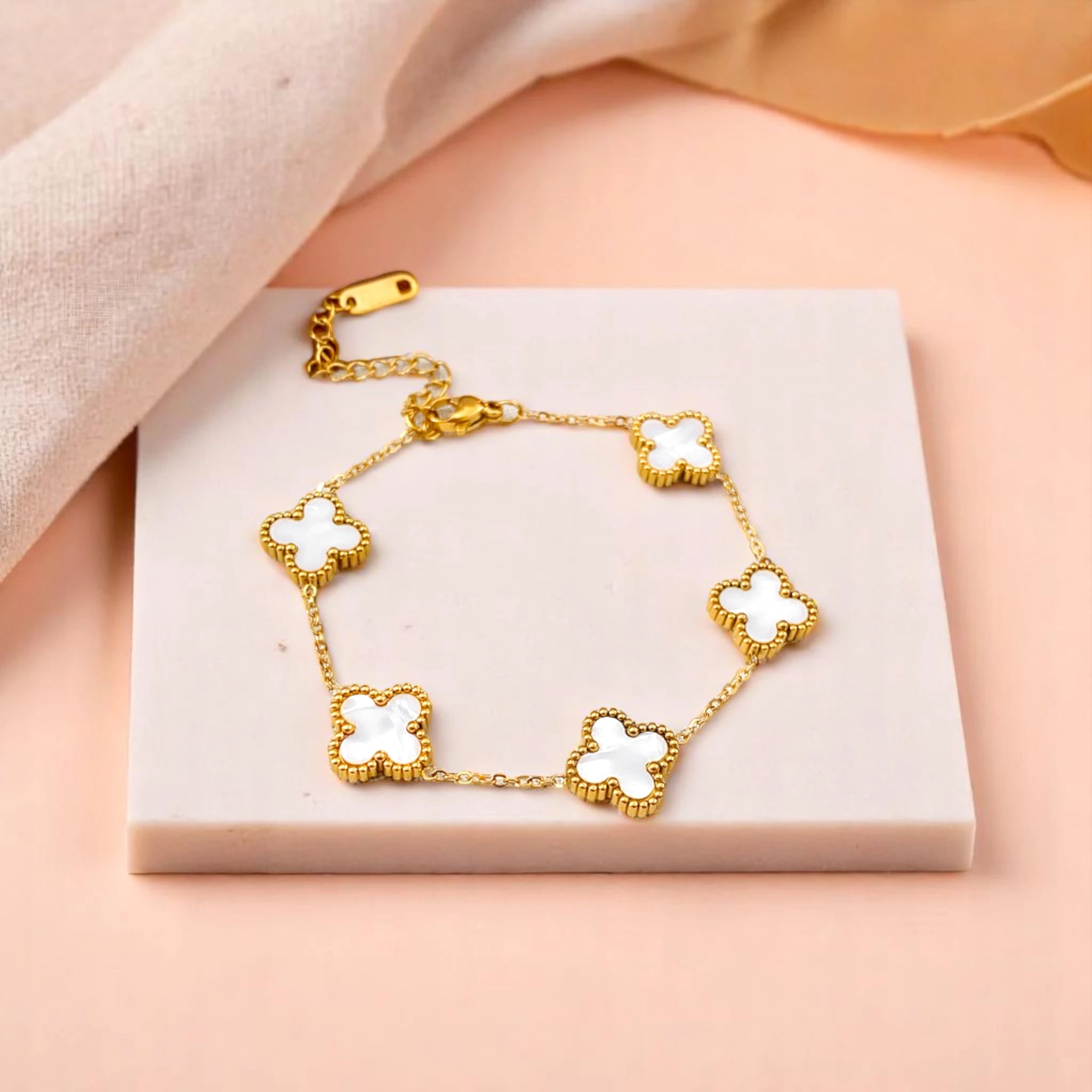 Bracelet on geometric prop with peach color gradient in the background.